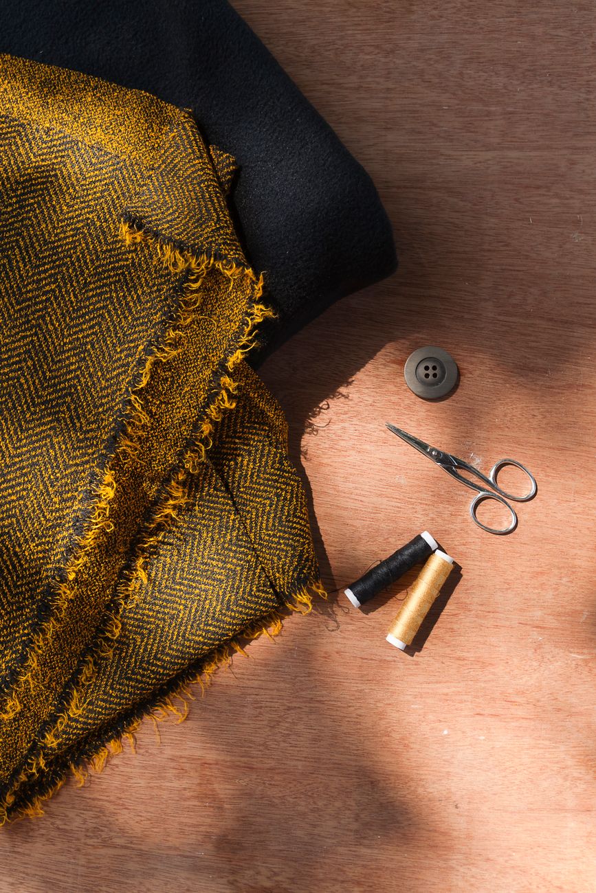 sewing threads and scissors beside a fabric
